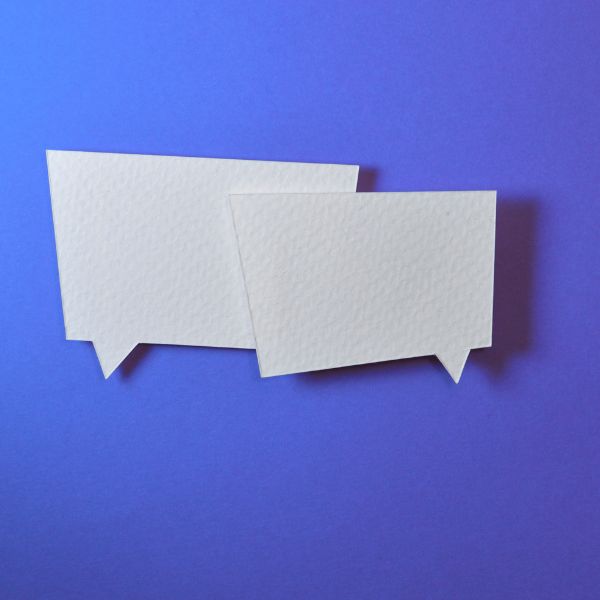 Zwei leere weiße Sprechblasen aus Papier auf blauem Hintergrund
